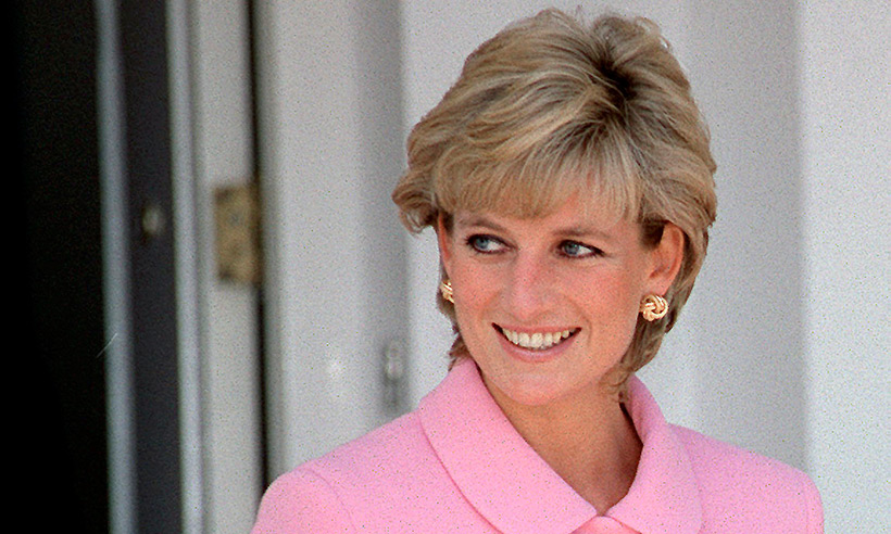 Lady Diana v růžovém oblečení se usmívá.
