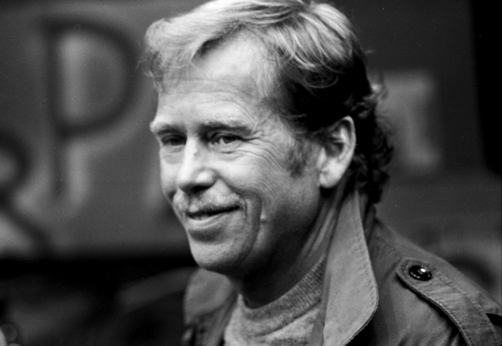 Václav Havel na černobílém snímku z profilu se usmívá.